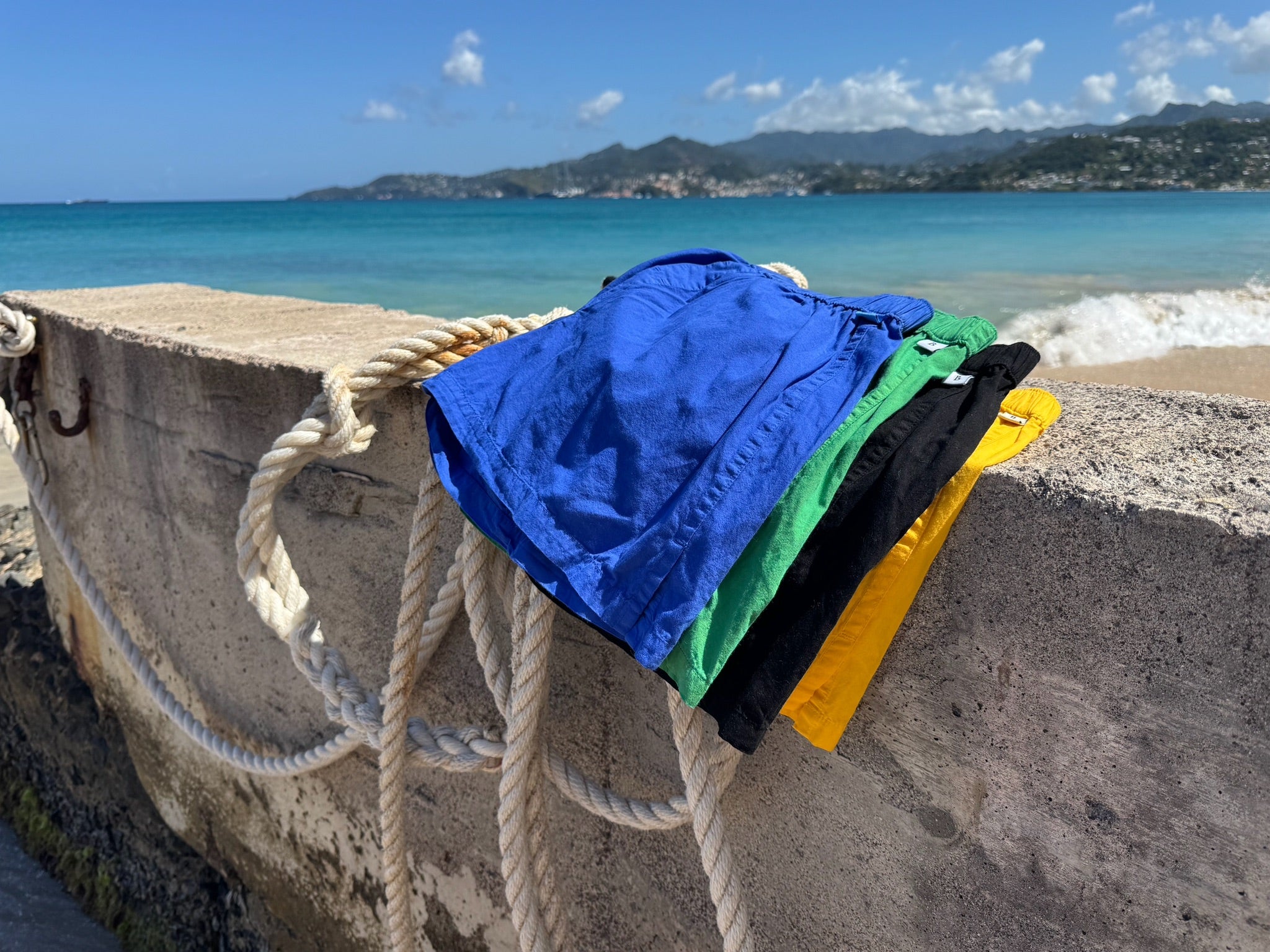 Four pairs of Bye Boxers on a sea wall on a beach